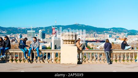 BARCELONA, SPANIEN - 18. JANUAR 2020: Leute an der Spitze des Montjuic Hil in Barcelona, Spanien hängend, mit der Stadt unter ihnen und den Tibidabo Hill Stockfoto