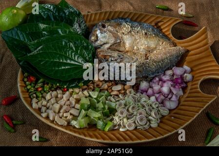 Traditionelle thailändische Essen: Gebratene Makrele serviert mit frischem Gemüse und Kraut, das Essen ist das thailändische Essen call Meuang Makrele (Maing-Pla-zu). Stockfoto