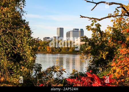 Landschaftlich schöner Blick auf die Innenstadt von Tulsa vom Westufer des Arkansas Flusses durch die Bäume. Stockfoto