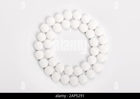 Weiße Tabletten in einem Kreis auf weißem Hintergrund, Ansicht von oben, in der Medizin Begriff Stockfoto