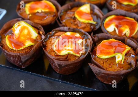 Frisch gebackene britische Cupcakes Muffins mit Karamelläpfeln und braunem Zuckersirup liegen ganz nah Stockfoto