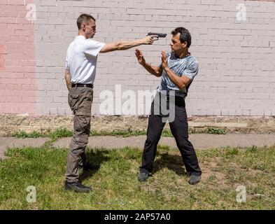 Verteidiger verteidigt sich mit einer Waffe gegen den Angreifer. Selbstverteidigungsmethoden Krav Maga Stockfoto