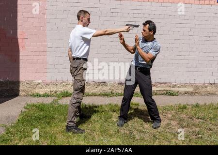 Verteidiger verteidigt sich mit einer Waffe gegen den Angreifer. Selbstverteidigungsmethoden Krav Maga Stockfoto