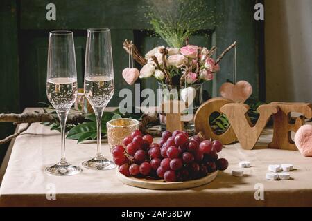 St. Valentines Tag oder Hochzeit romantisch gedeckten Tisch mit Holz Buchstaben Liebe, Nadel gefilzte Herzen, Blumenstrauß aus Rosen, ein Paar Gläser champagn Stockfoto