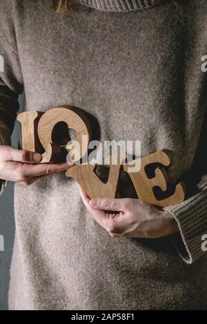 Holz- buchstaben wort Liebe in weibliche Hände. St Valentines Tag Grußkarte Stockfoto