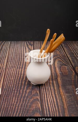 Geräte zum traditionellen chinesischen Teetrinken aus Bambus in weißer Keramikvase im chinesischen Stil auf Holzhintergrund. Nahaufnahme Stockfoto