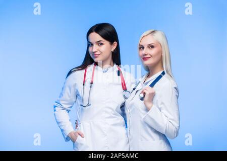 Ein Team junger Bewohner. Arzt, Krankenschwester und Chirurg in blauem Hintergrund. Eine Gruppe von Medizinstudenten verschiedener Nationalitäten sucht in der Schule Stockfoto
