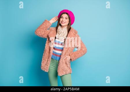 Portrait des hübschen Mädchens berühren ihren hellen Beret genießen Sie Winterherbstferien Stare in der Kamera tragen Sie einen stilvollen Pullover isoliert über blaue Farben Stockfoto