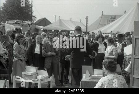 1950er Jahre, historisch, nach dem Krieg Großbritannien, auf einer Landmesse in einem Stall, der Nylone verkauft, ein geeigneter Verkäufer, der ein Paar zu den beobachtenden Besuchern zeigt, England, Großbritannien. Stockfoto