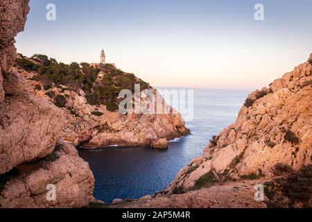 Far de Capdepera Leuchtturm, Sonnenuntergang mit weichem Licht, Bucht mit Felsen und Bäumen, Cala Ratjada, Mallorca, Spanien. Stockfoto