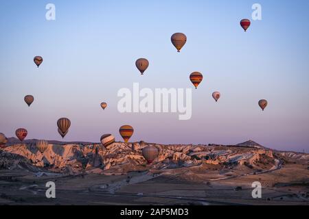 Kappadokien, Türkei, Europa: Heißluftballons im Morgengrauen und Blick auf das Tal um Cavusin, die Stadt der historischen Region in Zentralanatolien Stockfoto