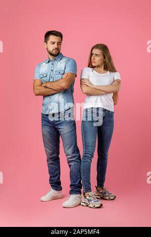 Das Paar argumentierte und rete sich gegenseitig: Junge Frau und ihr Freund standen auf pinkfarbenem Hintergrund Stockfoto