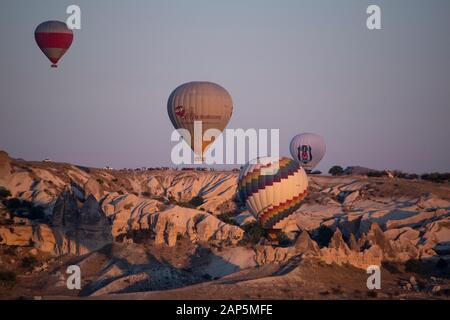 Kappadokien, Türkei, Europa: Heißluftballons im Morgengrauen und Blick auf das Tal um Cavusin, die Stadt der historischen Region in Zentralanatolien Stockfoto