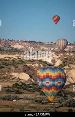 Kappadokien, Türkei, Europa: Heißluftballons im Morgengrauen und Blick auf das Tal um Cavusin, die Stadt der historischen Region in Zentralanatolien Stockfoto