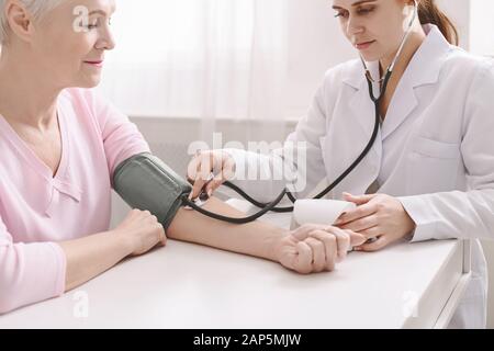 Arzt zur Messung des arteriellen Blutdrucks bei einem leitenden Patienten Stockfoto