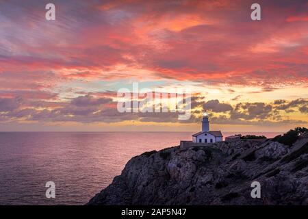 Der Leuchtturm Far de Capdepera, Sonnenaufgang mit wunderschönem farbenfrohem Himmel und Leuchtturmlicht, Cala Ratjada, Mallorca, Spanien. Stockfoto