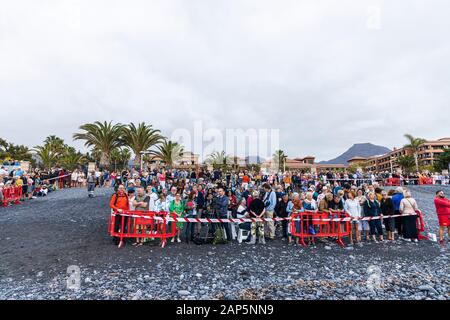 Massen von Menschen warten auf die Ankunft der Pferde am Strand von San Sebastian Fiesta in La Caleta Costa Adeje, Teneriffa, Kanarische Inseln. Stockfoto