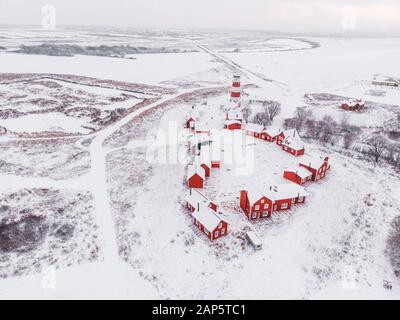 Blick auf die farbenfrohen Holzgebäude. Fischerdorf und Touristenstadt. Rote Holzhäuser des Fischerdorfs in schneebedecktem Schnee im Winter. Stockfoto