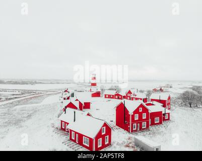 Blick auf die farbenfrohen Holzgebäude. Fischerdorf und Touristenstadt. Rote Holzhäuser des Fischerdorfs in schneebedecktem Schnee im Winter. Stockfoto