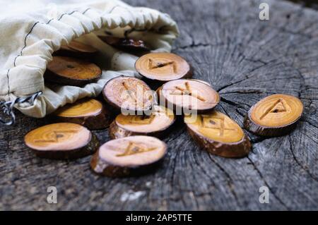 Holz- Runen in einem Canvas Tasche auf ein alter Baumstumpf Stockfoto