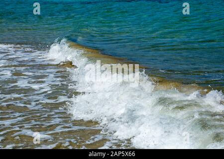 Kleine Wellen und Schaum an einem Meeresufer. Famagusta, Türkische Republik Nordzypern Stockfoto