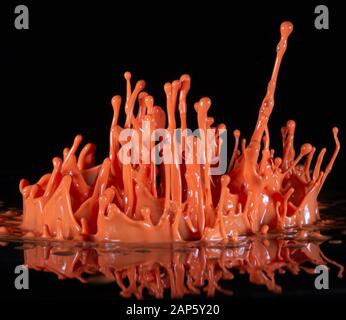 Orange Tinte spritzen auf schwarzem Hintergrund Stockfoto