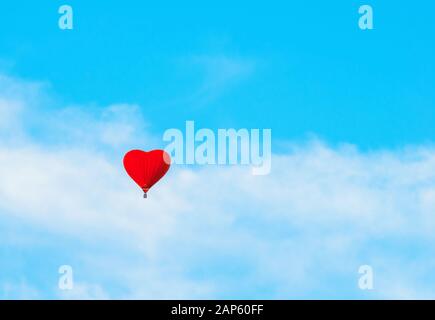 Roter Ballon in Herzform am blauen Himmel. ST Valentines Day Landschaft, romantischer Abenteuerhintergrund mit Liebe und St Valentines Day Konz Stockfoto