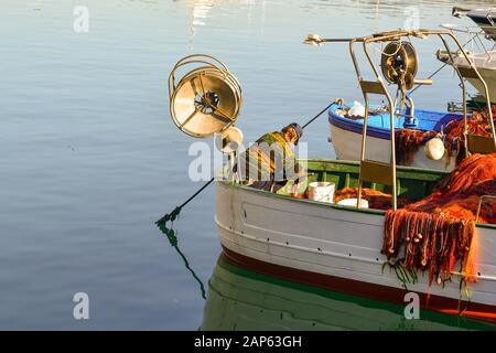 Ein Fischer, der frisch gefangenen Fisch aus den Netzen seines Bootes entfernt, der im Hafen von Porto Maurizio, Imperia, Ligurien, Italien gefestigt ist Stockfoto