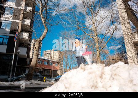 Frau zu Fuß durch die Schneeschmelze im späten Winter Stockfoto