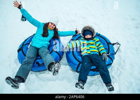 Junge Frau mit Kind auf Schnee Rohre Stockfoto