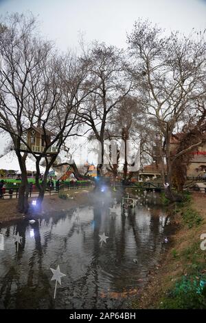 Kleiner, dekorierter Teich und Baumhaus in einer Gegend, die als Veranstaltungsort für die "Elfenmesse" genutzt wird, die zu Weihnachten stattfindet. Trikala, Griechenland. Stockfoto