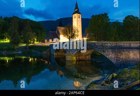 Kirche Sv. Johannes der Täufer und eine Brücke von der Bohinjer See in der Nacht, Slowenien. Kirche des Hl. Johannes des Täufers mit Brücke. Nationalpark Triglav, J Stockfoto