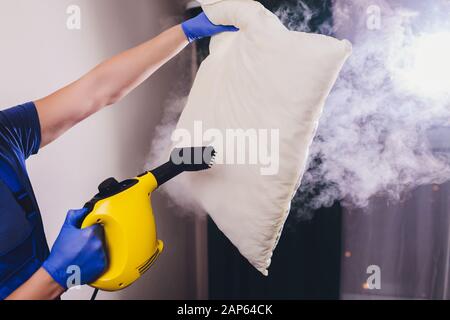 Mit trockenem Dampfreiniger Kissen desinfizieren Stockfoto