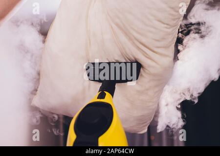 Mit trockenem Dampfreiniger Kissen desinfizieren Stockfoto