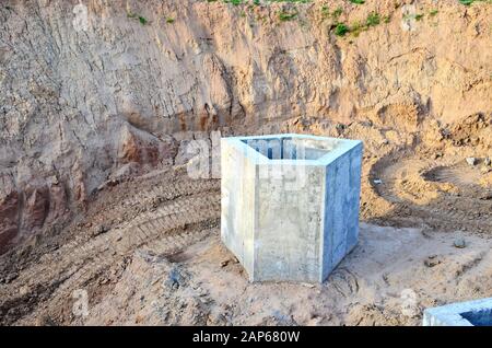 Installation von konkreten Abwasserkanal Vertiefungen im Boden auf der Baustelle. Die Verwendung von Stahlbeton Ringe für Senkgruben, Überlauf Klärgruben Stockfoto