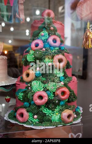 In einem Schaufenster wird ein buntes Weihnachtsbaumkuchen gezeigt. Stockfoto