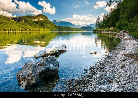 Küstenlinie im Altausseer See mit einigen Felsen, entfernter Dachsteingebirge Stockfoto