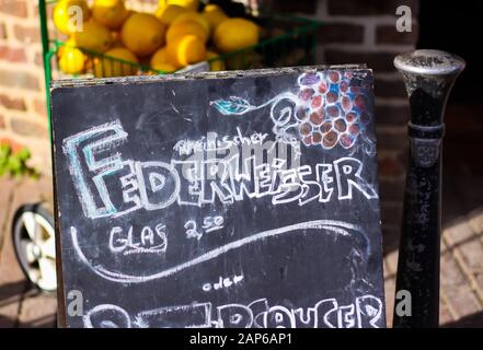 Nahaufnahme der schwarzen Kreideplatte mit Federweisser (was heißt fermentierter frisch gepresster Traubensaftwein), Deutschland Stockfoto