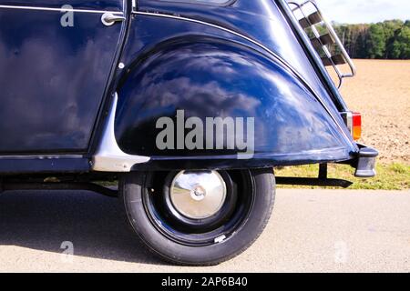 Viersen, Deutschland - 12. Oktober. 2019: Blick auf den hinteren Radkasten des schwarzen französischen Oldtimer-Kultwagens 2CV mit Holzgepäckträger im ländlichen Raum Stockfoto