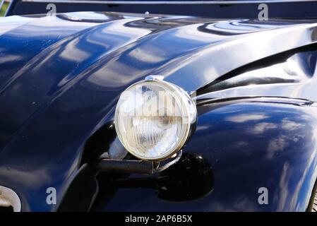 Viersen, Deutschland - 12. Oktober. 2019: Nahaufnahme des isolierten silbernen Chromscheinwerfers des schwarzen französischen Oldtimer 2CV im ländlichen Raum Stockfoto