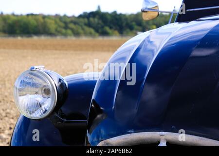 Viersen, Deutschland - 12. Oktober. 2019: Nahaufnahme des isolierten silbernen Scheinwerfers des schwarzen französischen Oldtimer-Kultwagens 2CV im ländlichen Raum Stockfoto