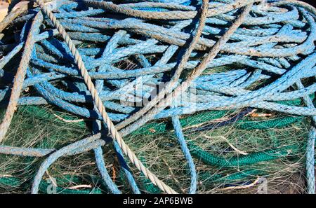 Nahaufnahme des Haufens blauer Schiffsseile auf grünem isoliertem Fischernetz Stockfoto