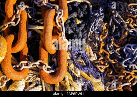 Vollformatseile Nahaufnahme alter rostiger brauner Ankerkettenglieder an Banden von Bootsseilen bei natürlichem Sonnenschein Stockfoto