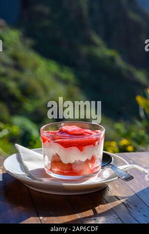 Süßes Dessert, Käse Kuchen mit Mousse und roten Kaktusfeigen Marmelade im Glas serviert. Stockfoto