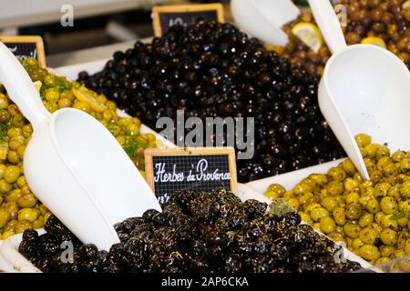 Nahaufnahme von isolierten grünen und schwarzen frischen französischen Oliven, gewürzt mit Kräutern aus der Provence auf dem Bauernmarkt - St. Tropez, Frankreich Stockfoto