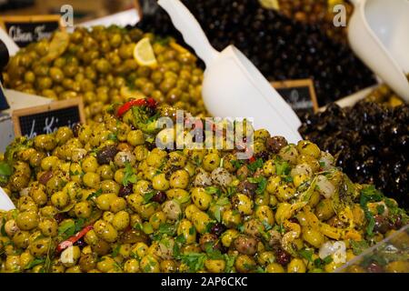 Nahaufnahme von isolierten grünen und schwarzen frischen französischen Oliven, gewürzt mit Kräutern aus der Provence auf dem Bauernmarkt - St. Tropez, Frankreich Stockfoto