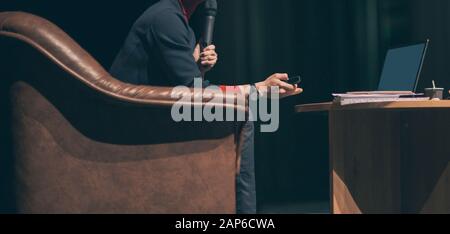 Seitenansicht. Business Coach in einem Stuhl vor dem offenen Laptop sitzen. Stockfoto