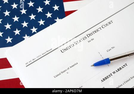 Gerichtliche Haftpapiere des Distrikts und blauer Stift auf der Flagge der Vereinigten Staaten. Konzept der Erlaubnis, einen Verdächtigen festzunehmen Stockfoto