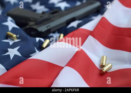 9 mm Kugeln und Pistole liegen auf gefalteter US-Flagge. Eine Reihe von Selbstschutzelementen oder ein spezielles Servicekit Stockfoto