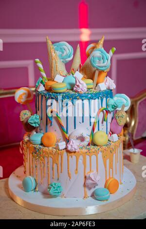 Blauer Kuchen mit bunt kleinem süßen Ball. Dekoration für Kuchen und Bekleierung. Farbenfroher Kuchen in Waffelkonus für Eis im Sortiment, dekoriert Stockfoto